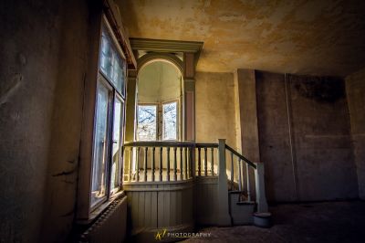 Ein Zimmer mit einem Fenster und einer Treppe