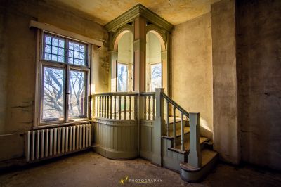 Ein Zimmer mit einem Fenster und einer Treppe