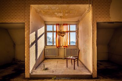 Ein Stuhl in einem Zimmer mit Fenster