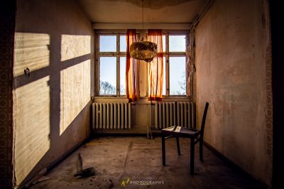 Ein Stuhl in einem Zimmer mit Fenster