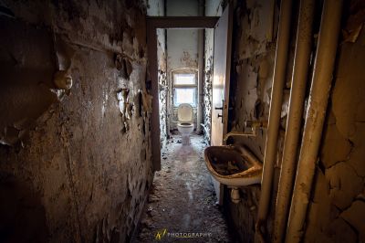 Ein schmutziges Badezimmer mit einer Toilette und einer Wand