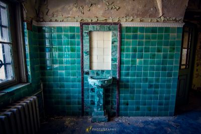 Ein Badezimmer mit einem gebrochenen Waschbecken und einem zerbrochenen Fenster