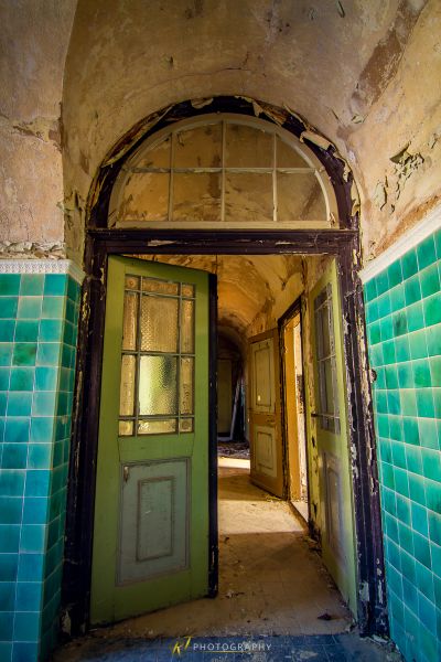 Eine Tür mit einer grünen Tür und einer grünen gefliesten Wand