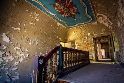 Ein Raum mit einer Treppe und einer Decke mit schälender Farbe