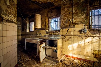 Eine schmutzige Küche mit Herd und Waschbecken