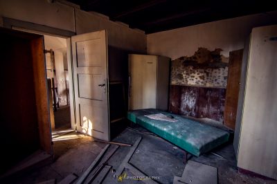 Ein Bett in einem Zimmer mit einer Tür und einer Wand