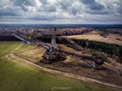 Ein großer Kran ist in einem Feld mit einem bewölkten Himmel