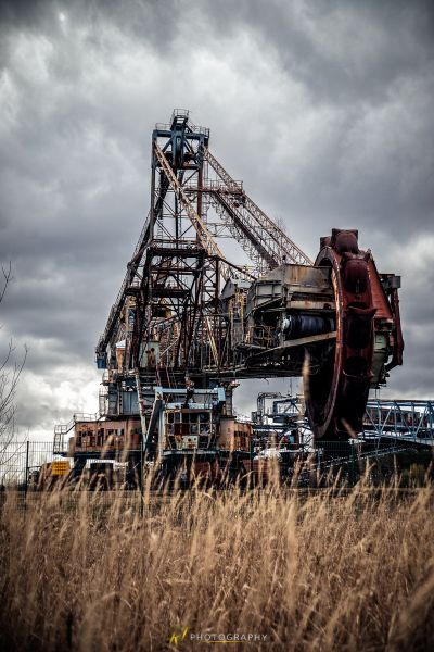 Ein großer Kran, der auf einem Feld aus hohem Gras sitzt