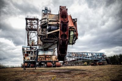 Eine große rostige Maschine, die auf einem Feld sitzt