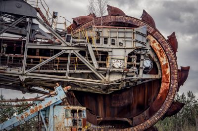 Eine große verrostete Maschine, die in einem Feld sitzt