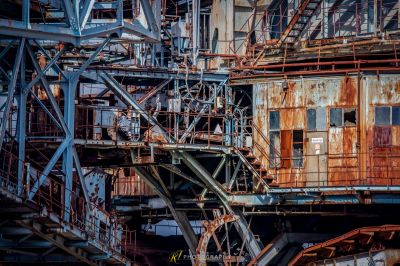 Ein verrostetes Gebäude mit einer Feuerhydra im Hintergrund