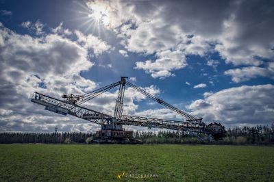 Ein großer Kran ist in einem Feld mit einem Himmel Hintergrund