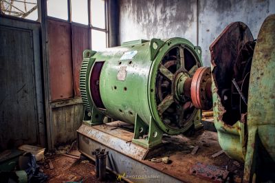 Eine grüne Maschine, die in einem Raum mit einem kaputten Fenster sitzt