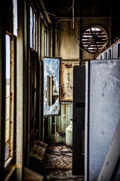 Ein Zimmer mit einem kaputten Kühlschrank und einem kaputten Fenster