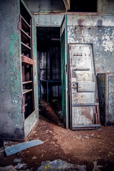 Ein schmutziges Zimmer mit Kühlschrank und Tür