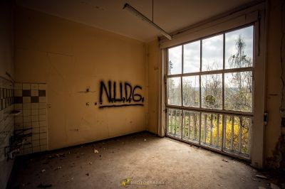 Ein Zimmer mit einem Fenster, das Graffiti drauf hat