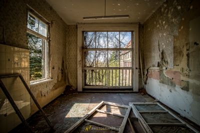 Ein Zimmer mit einem kaputten Fenster und einer kaputten Tür