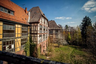 Ein Haus mit einem roten Dach und einem schwarzen Zaun