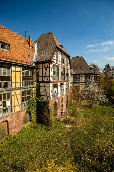 Ein Haus mit einem roten Dach und einem weißen Zaun