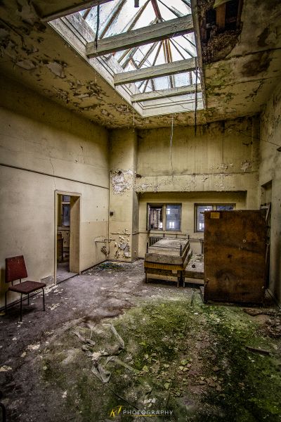 Ein Zimmer mit einer kaputten Decke und einem Stuhl