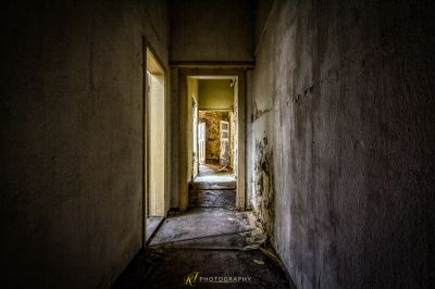 Ein langer schmaler Flur mit einer Tür, die zu einem Raum führt