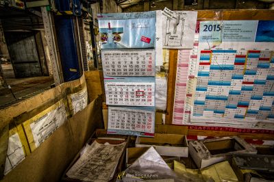 Ein Haufen Papiere und Kalender sind an einer Wand gestapelt