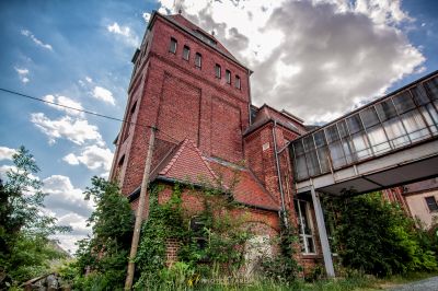 Ein hohes Backsteingebäude mit einer Uhr auf der Oberseite