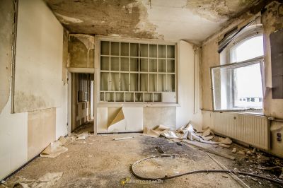 Ein Zimmer mit einem Fenster und einer Wand mit vielen Trümmern