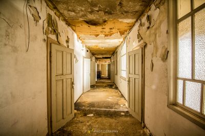 Einen langen Flur mit einer zerbrochenen Decke und einem zerbrochenen Fenster