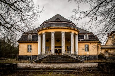 Ein gelbes Gebäude mit einer großen Veranda und einer großen Veranda