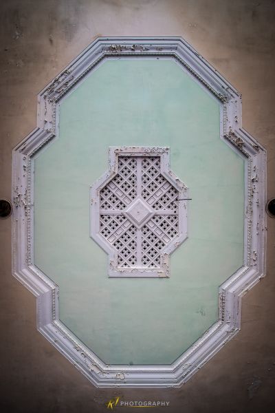 Eine grüne Wand mit einem weißen Fenster und einem weißen Rahmen