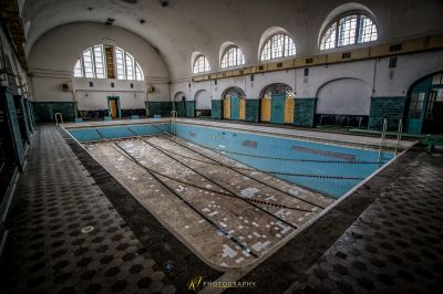 Ein Schwimmbad mit gefliestem Boden und einem großen Fenster