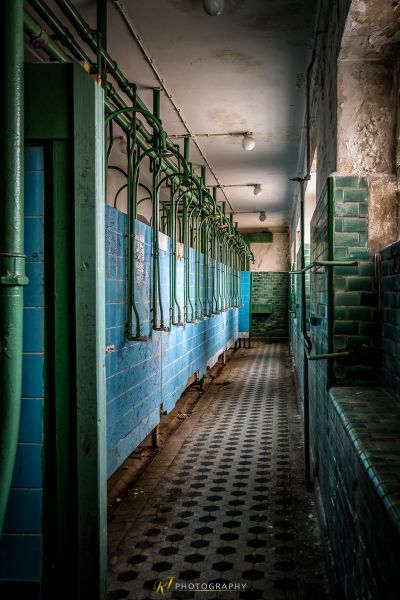 Ein langer Flur mit gefliestem Boden und blauen Wänden