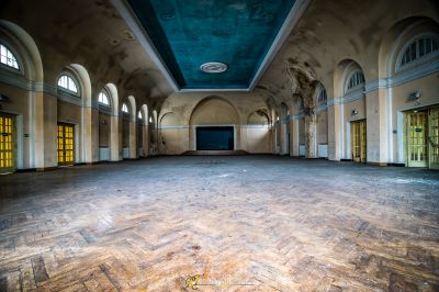 Ein großes Zimmer mit einer blauen Decke und einem Holzboden