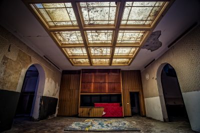 Ein Zimmer mit einer roten Couch und einer Decke