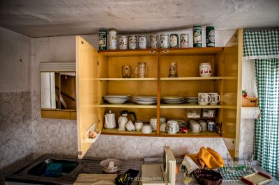 Eine Küche mit Waschbecken und einem Regal mit Geschirr