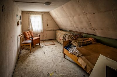 Ein Zimmer mit einem Bett und einem Stuhl