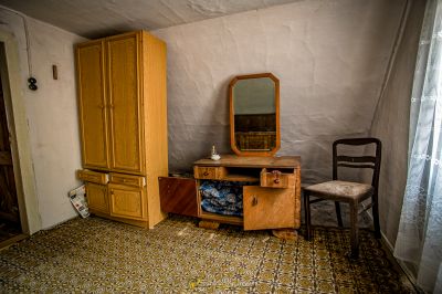 Ein Schlafzimmer mit Bett, Kommode und Spiegel