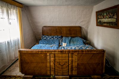 Ein Bett mit einem blauen Tröster und einem braunen Holzkopfteil