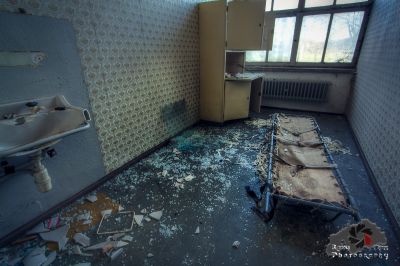 Ein Badezimmer mit einem gebrochenen Waschbecken und einem gebrochenen Spiegel