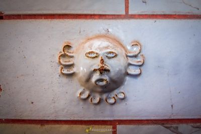 Ein weißer keramischer Tierkopf auf einer Ziegelwand