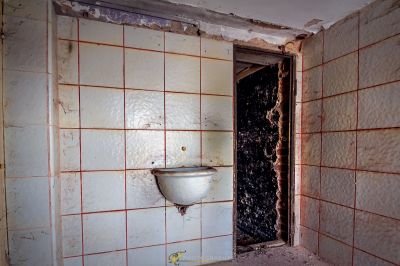 Ein Badezimmer mit einer Toilette und einer Wand aus Fliesen