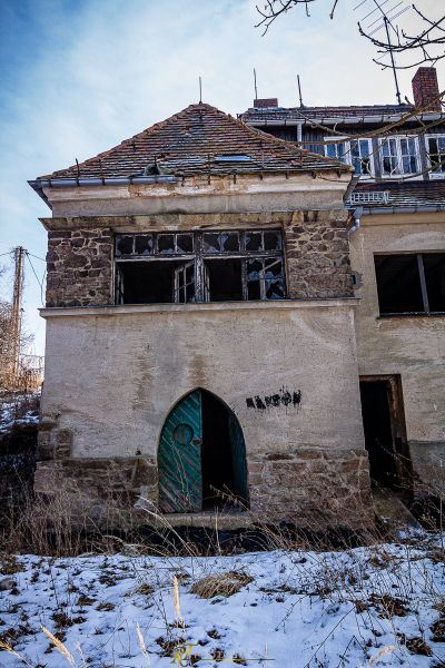 Ein Gebäude mit einer grünen Tür im Schnee