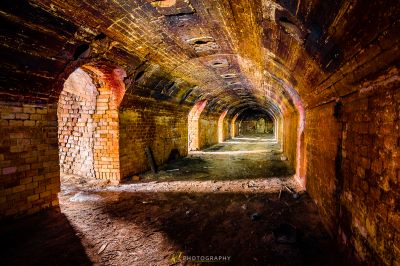 Ein Tunnel in einem Backsteingebäude mit einem Licht, das durch ihn kommt