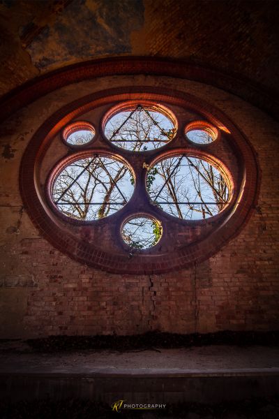 Ein kreisförmiges Fenster in der Ziegelwand