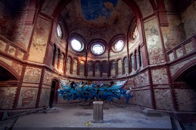 Ein großer Raum mit einem großen Fenster und einem Graffiti an der Wand