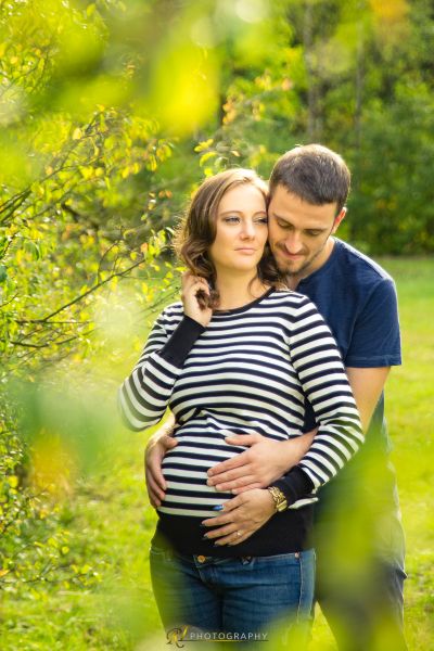 Ein schwangeres Paar Kuss im Wald