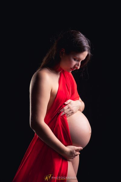 Eine schwangere Frau in einem roten Kleid