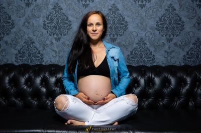 Eine schwangere Frau, die auf einer Couch sitzt