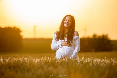 Eine Frau in einem weißen Kleid steht auf einem Feld